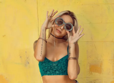 Woman in Blue Bralette Holding Sunglasses