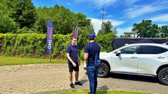 Lexus NX przekazywany kierowcy-partnerowy Flovi przez pracownika wypożyczalni One Rent.